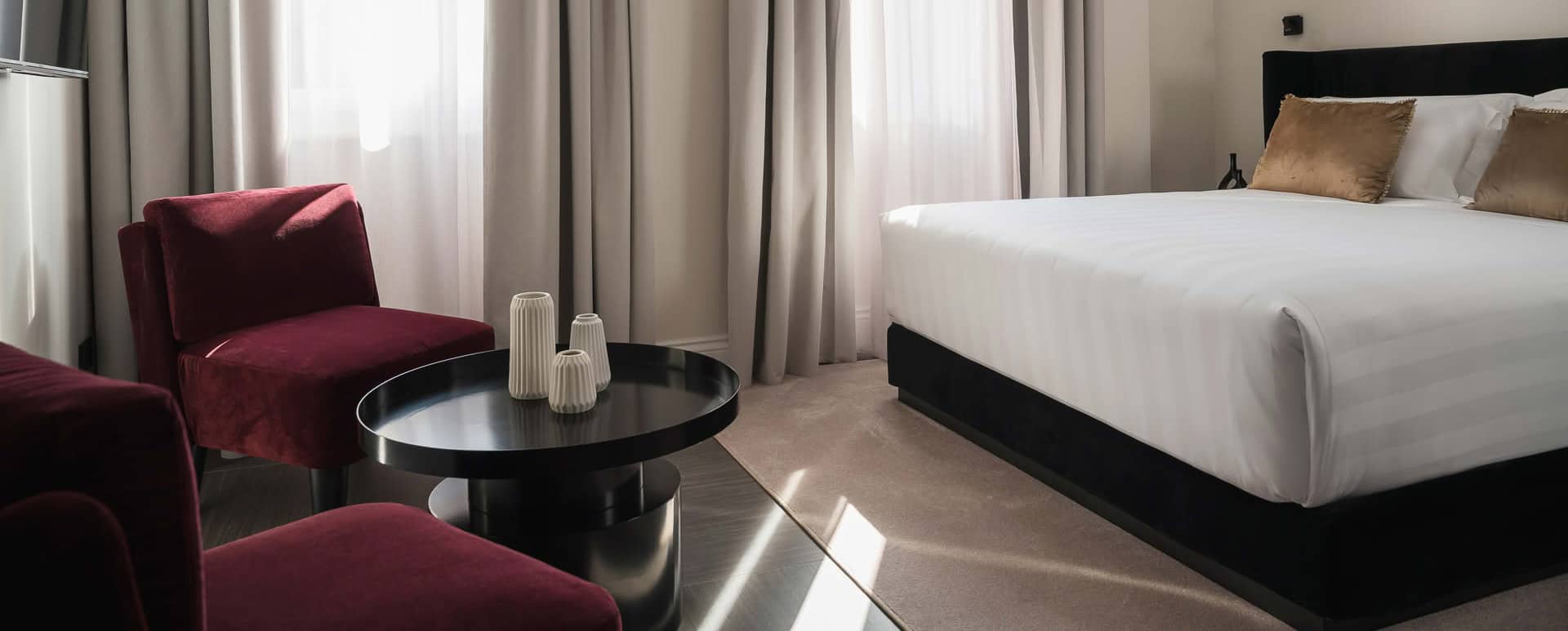 Dettaglio di una camera Deluxe di Casa Guttmann a Roma con letto matrimoniale e angolo relax