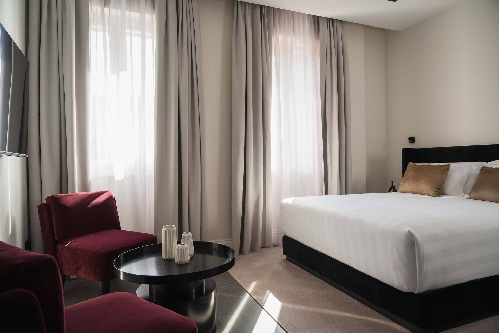 Dettaglio di una camera Deluxe di Casa Guttmann a Roma con letto matrimoniale e angolo relax